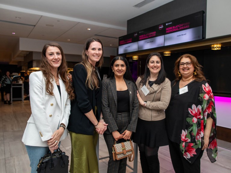 Five women pose for camera