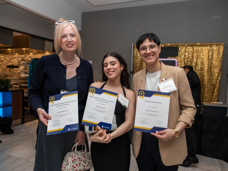 Three scholarship recipients pose for photo with their awards