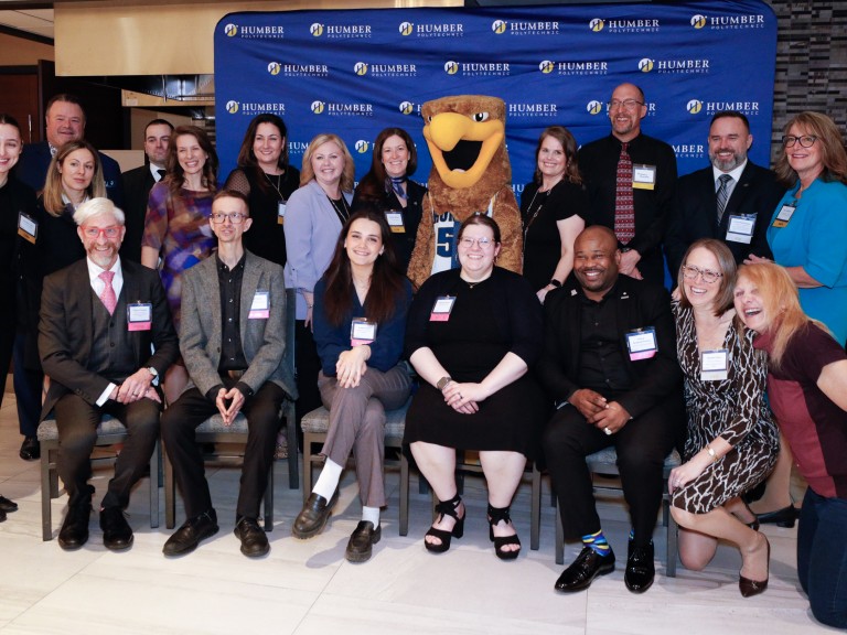 Group posing for photos with mascot