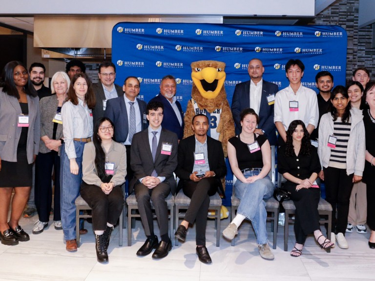 Group posing for photos with mascot