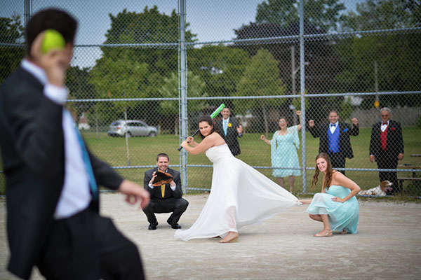 Andrea swinging the bat with her wedding dress on