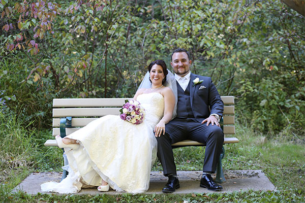Tyler and Jennifer sitting on a bench after getting married