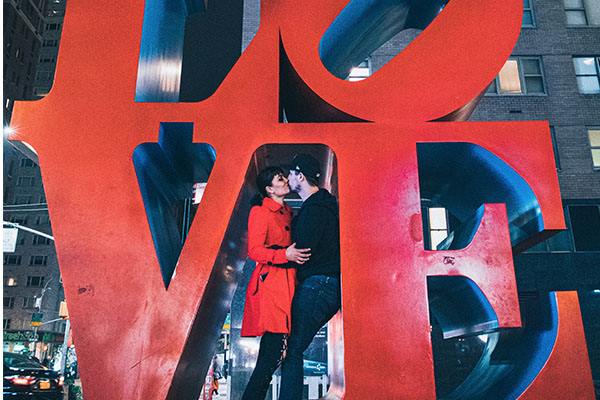 Rohma and Paul standing in front of a LOVE sign