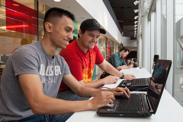two male students looking at a laptop