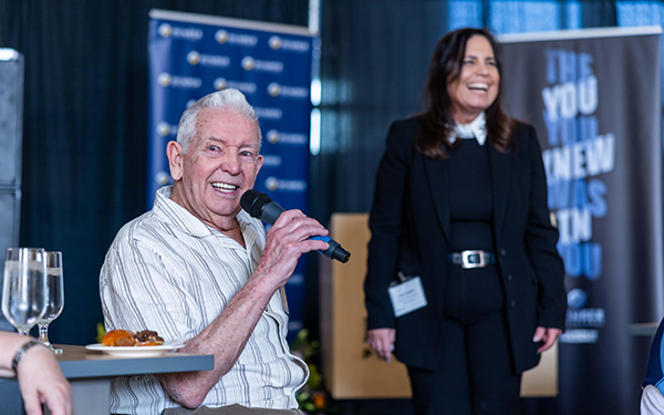 an old people smiling while holding mic in his hand