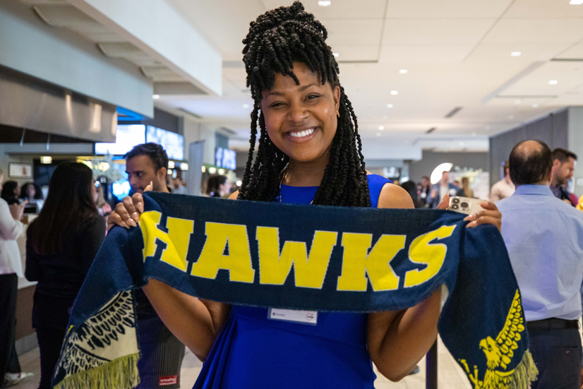 Person holds up Humber Hawks scarf at scholarship celebration night