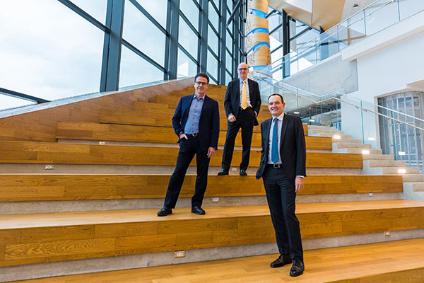 Three faculty members on the stairs of the Barrett Centre