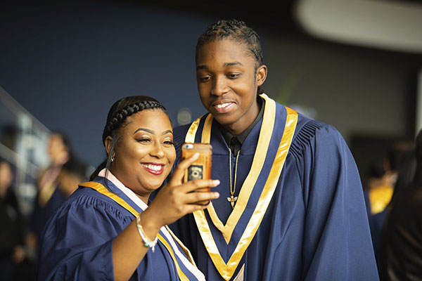 two students in Humber graduation regalia