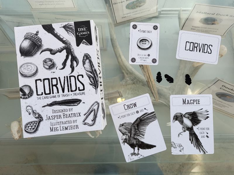 Cards and the box from the game Corvids feature cool black and white drawings 