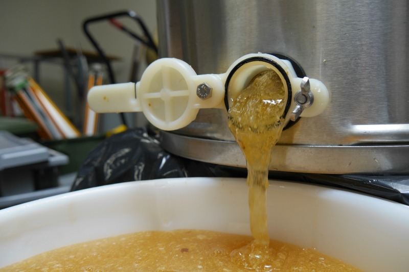 Honey pours from a centrifuge spout