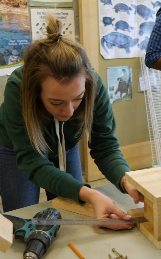 A student assembles a bird house
