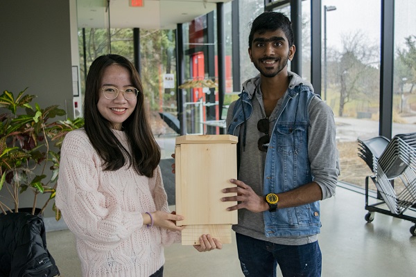 Students show off a bat box they have built together