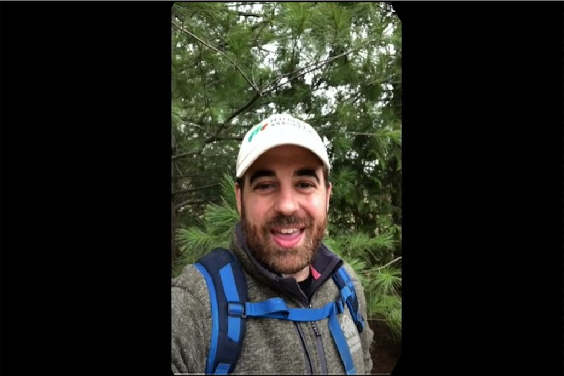 Screen capture of an educator doing a selfie video outdoors.