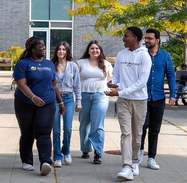 Five people walking on campus during campus tour