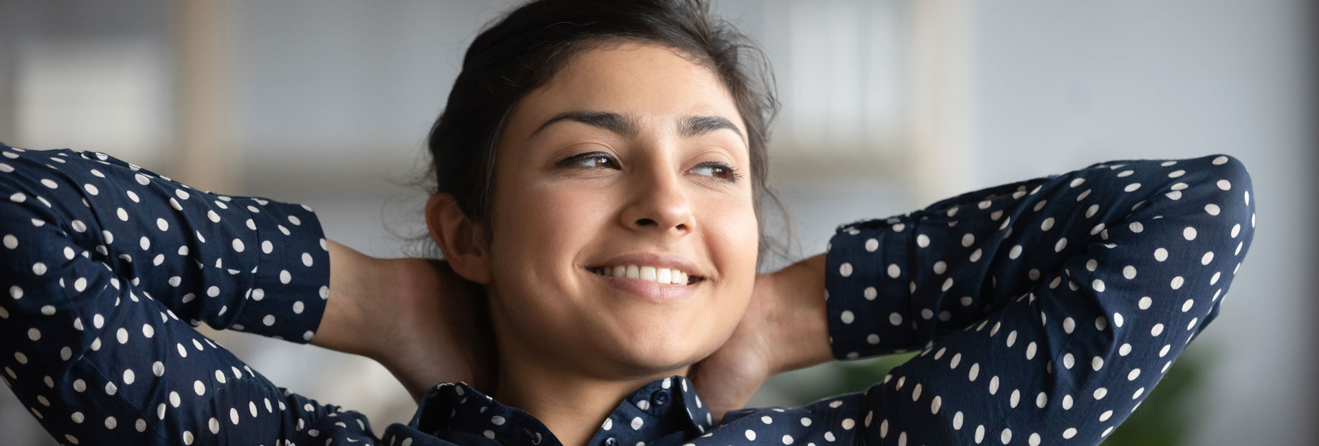 Person smiling with their hands behind their head