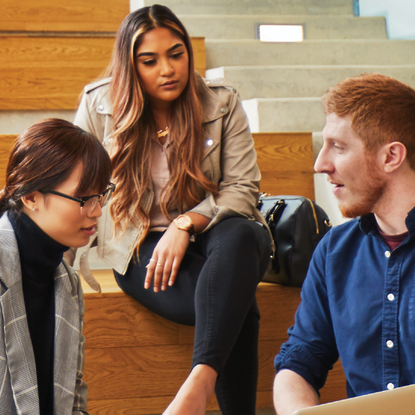 3 people sitting on a bench in the school