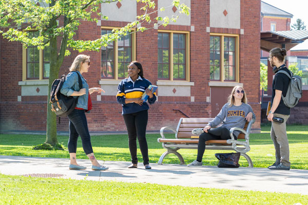 four students talking outside campus