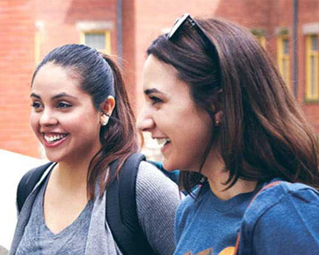 two people walking outside and smiling