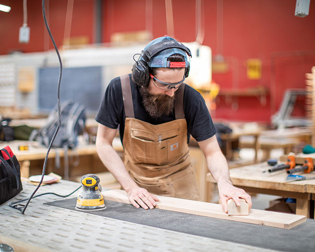 student sanding wood