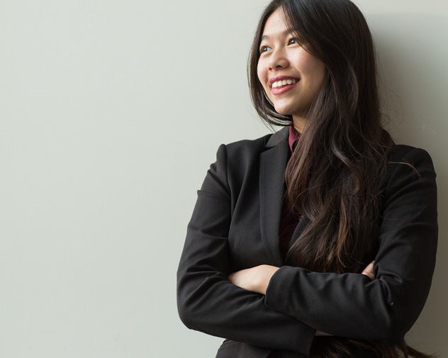 person smiling with their arms crossed