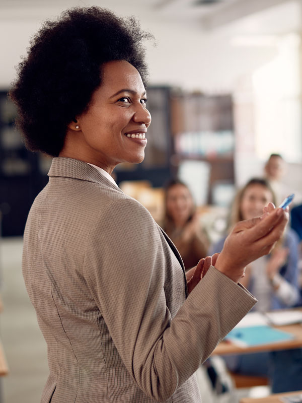 Teacher in classroom gesturing at presentation