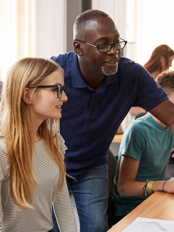 Student and teacher looking at computer