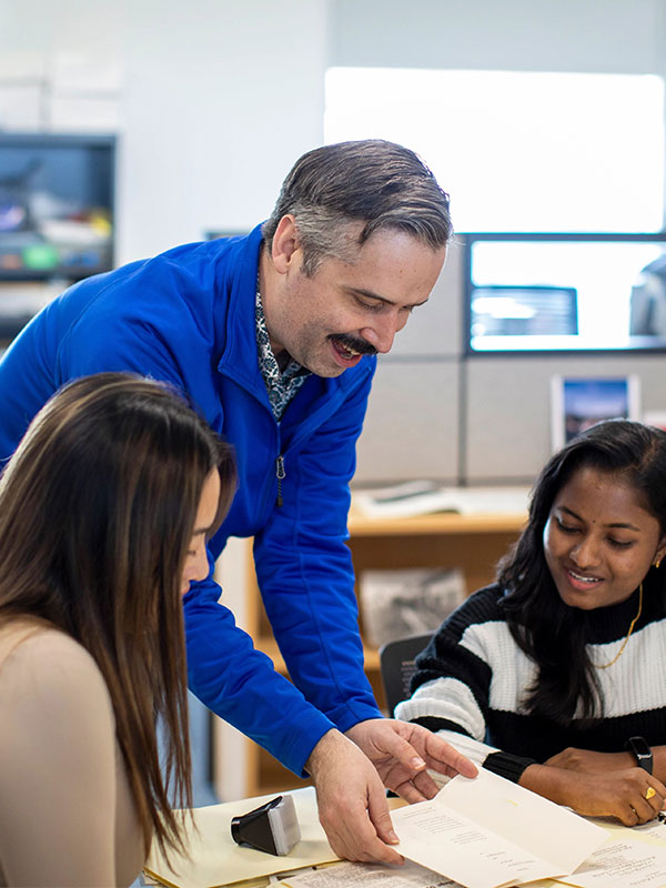 teacher helping two students