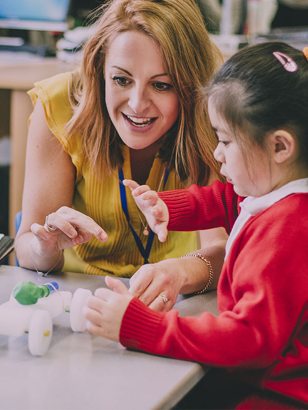 teacher showing a child a toy