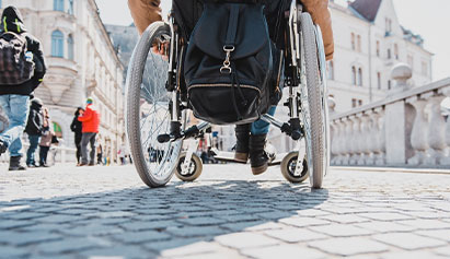 Person in a wheelchair on a cobblestone path