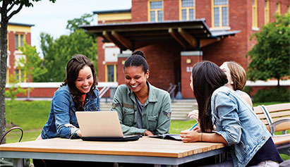 Group of students outside on a laptop