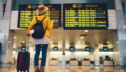 woman in airport looking at departure sign