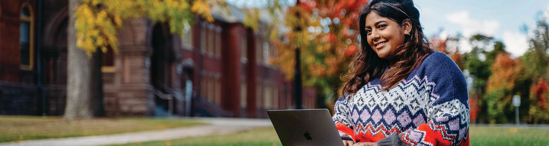 female student sitting on Humber's lawn