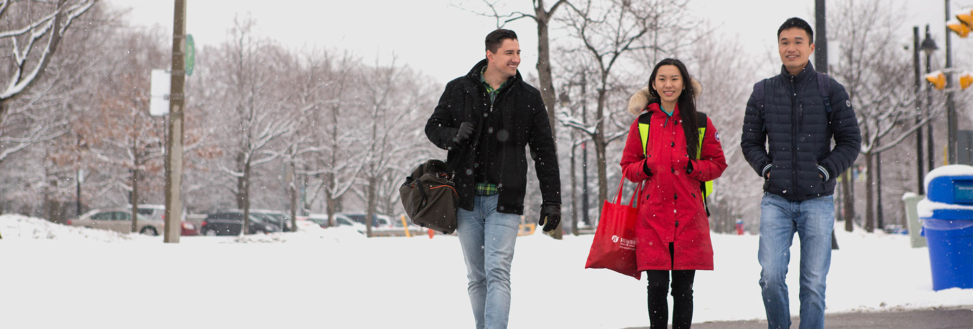 Three students walking outside in snowy weather