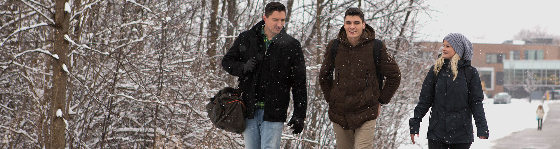 two males and a female walking outside in the winter