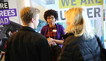 women talking to student and parents at event