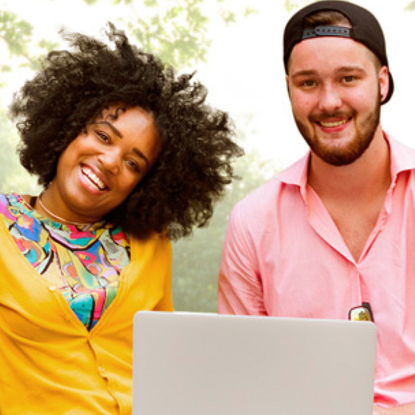 smiling students in front of a laptop