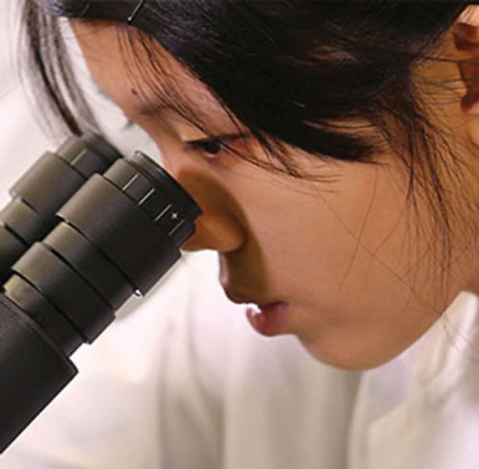 student looking through a microscope