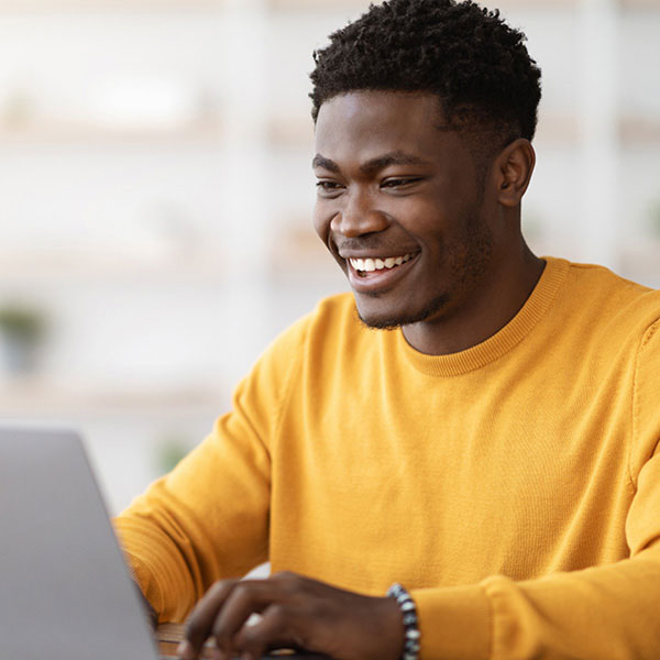 student smiling working at a computer