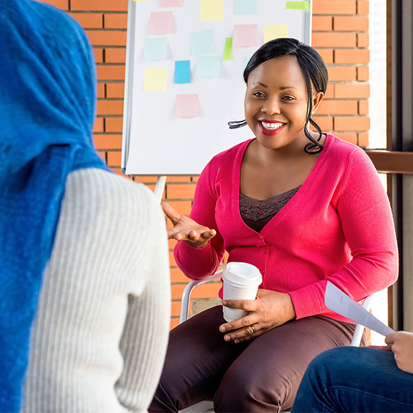 Diverse group of women in colorful clothes at the meeting, discussing social project