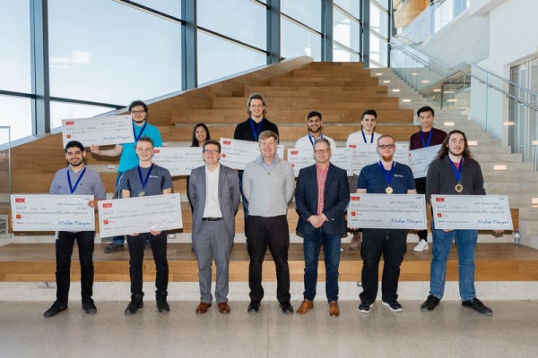 group photo with everyone holding novelty cheques