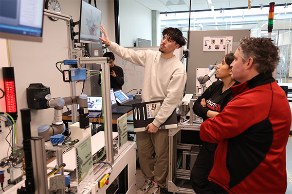 a group of faculty members looking at tech equipment