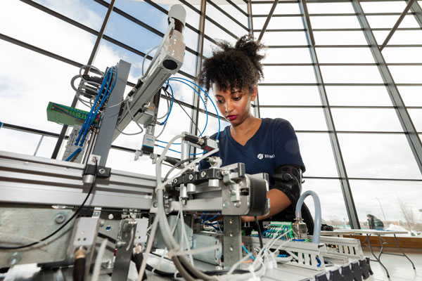 young woman working with mechatronics equipment