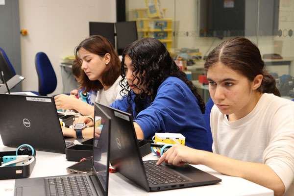 Three people working on electronics