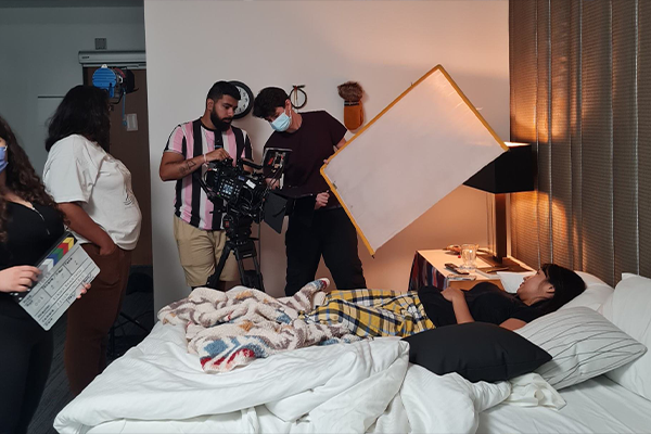 Filming set with person laying in bed
