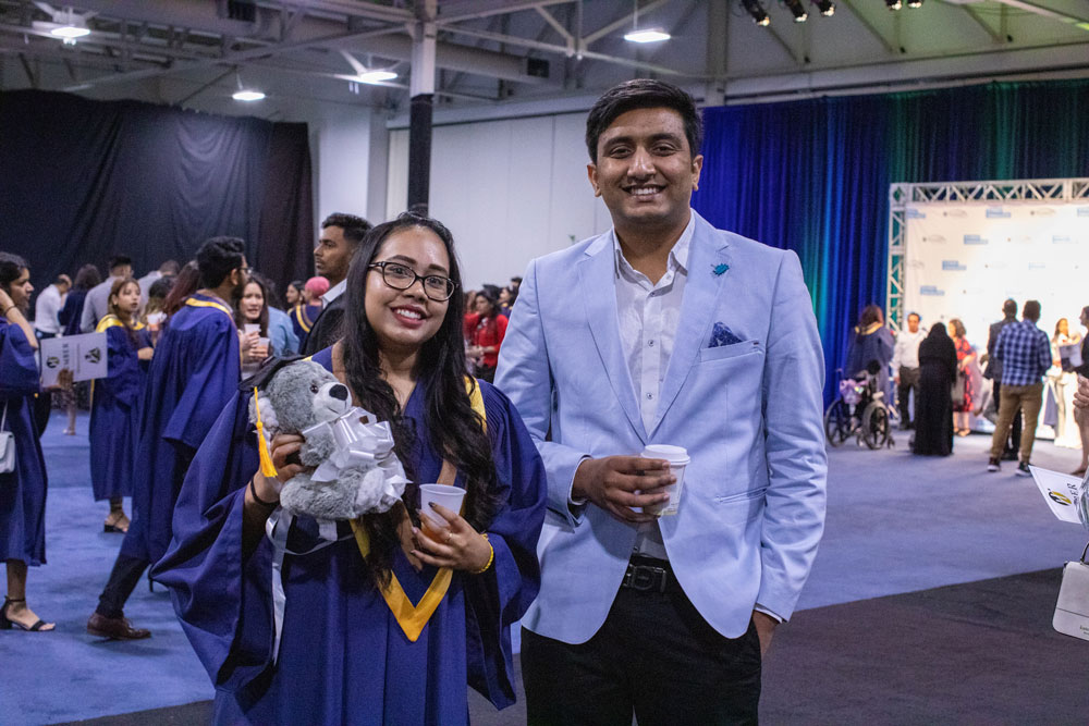 Humber graduate smiling at camera with friend