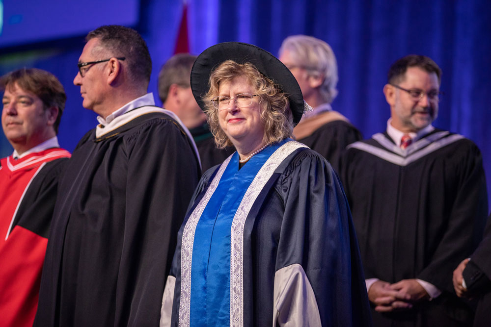 Faculty members in robes on stage