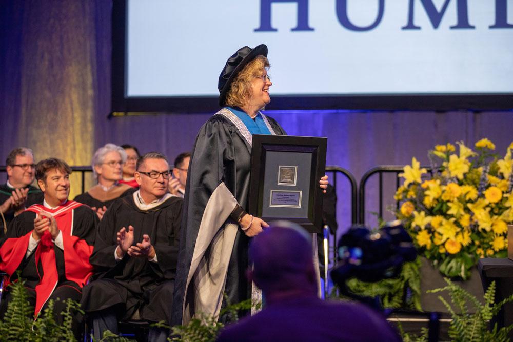 Ann Marie Vaughn holding award on stage