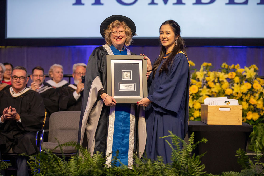 Ann Marie Vaughn and graduate posing together with award