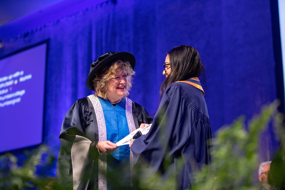 Ann Marie Vaughn presenting certificate to graduate on stage