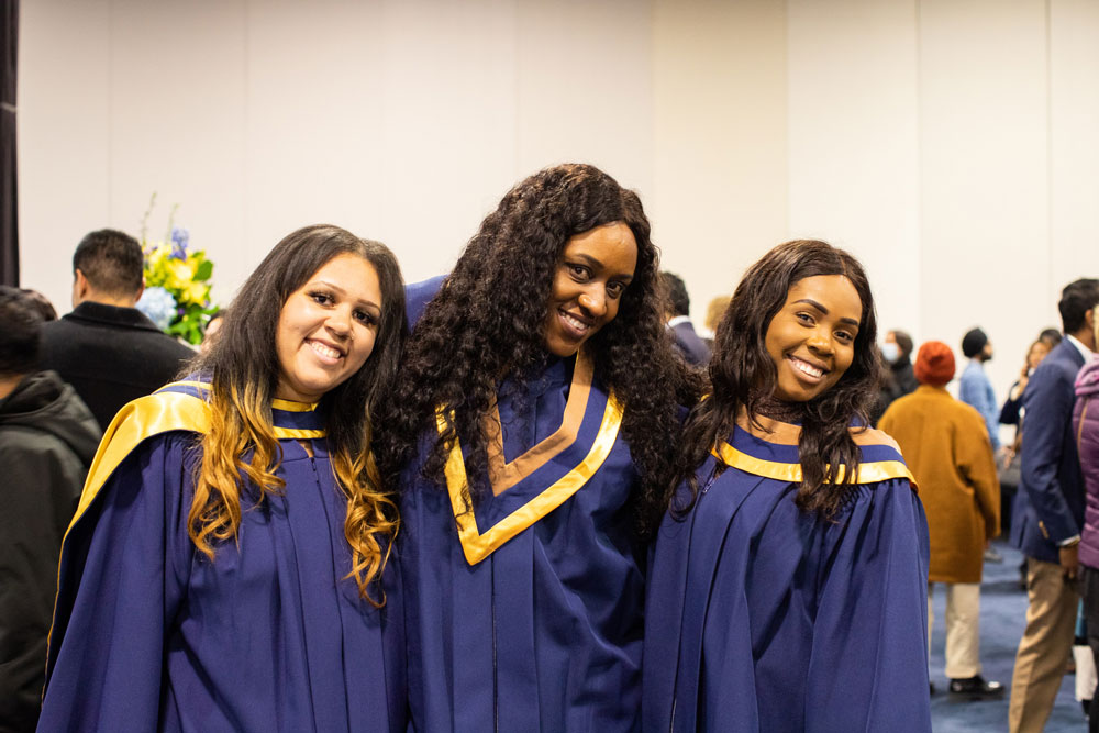 Three grads smiling